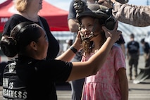 U.S. Marine Corps Sgt. Alexia Sawyers, left, a recruiter with Recruiting Station Seattle, 12th Marine Corps District, places an enhanced combat helmet on a girl at a static display of weapons and equipment during Seattle Seafair Fleet Week in Seattle, Aug. 3, 2024. The U.S. Navy, Coast Guard, and Marines have been involved in Seafair in some way since the festival began 75 years ago. The annual event provides service members an opportunity to interact with the American people and promotes the Navy-Marine Corps team as the nation’s expeditionary force in readiness. Sawyers is a native of Arizona. (U.S. Marine Corps photo by Sgt. Cameron Hermanet)