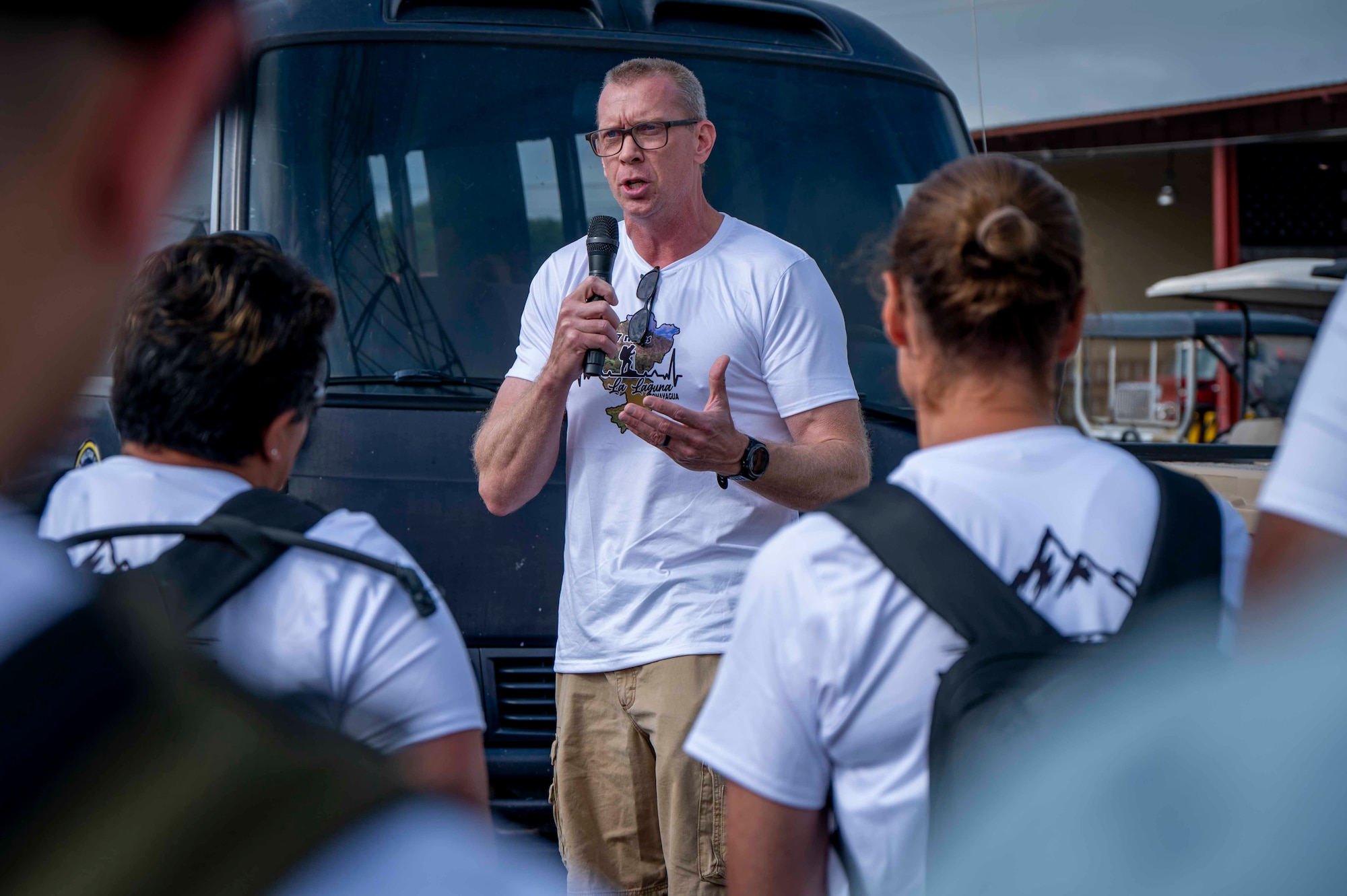 A person speaking in a microphone to a crowd of people.