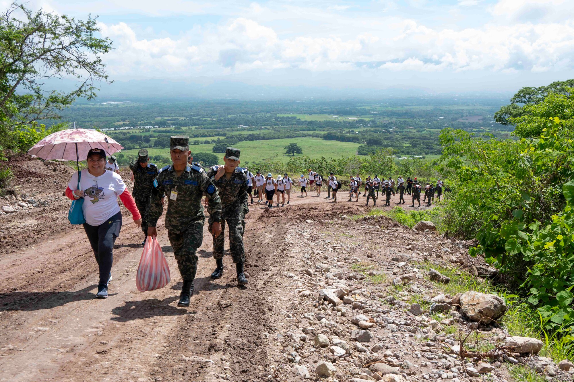 A long line of people walking up a mountain led by a few Honduran cadets.