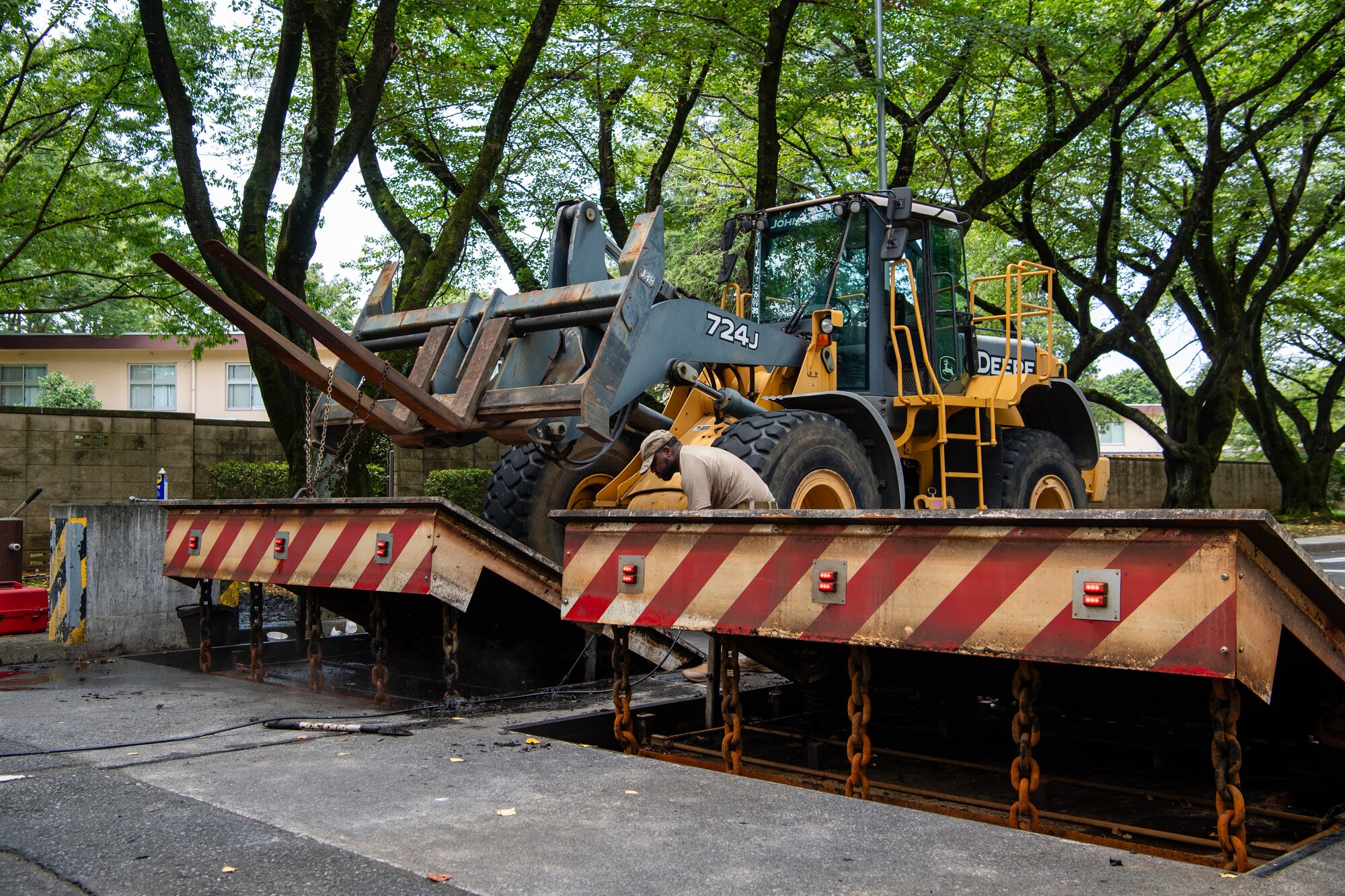 U.S. Air Force Tech. Sgt. Romain Smith, 374th Civil Engineer Squadron barrier maintenance NCO in charge, conducts maintenance on an active vehicle barrier system at Yokota Air Base, Japan.