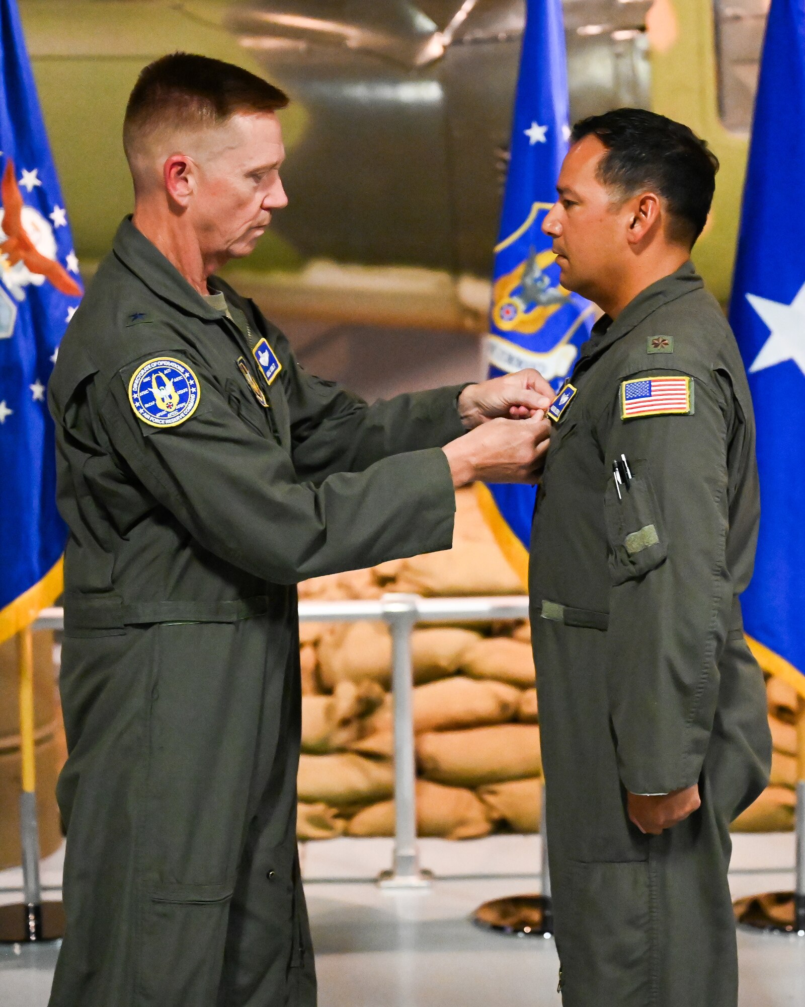Photo of Brigadier General Michael Schultz pinning Airman's medal on Major Michael Medrano.
