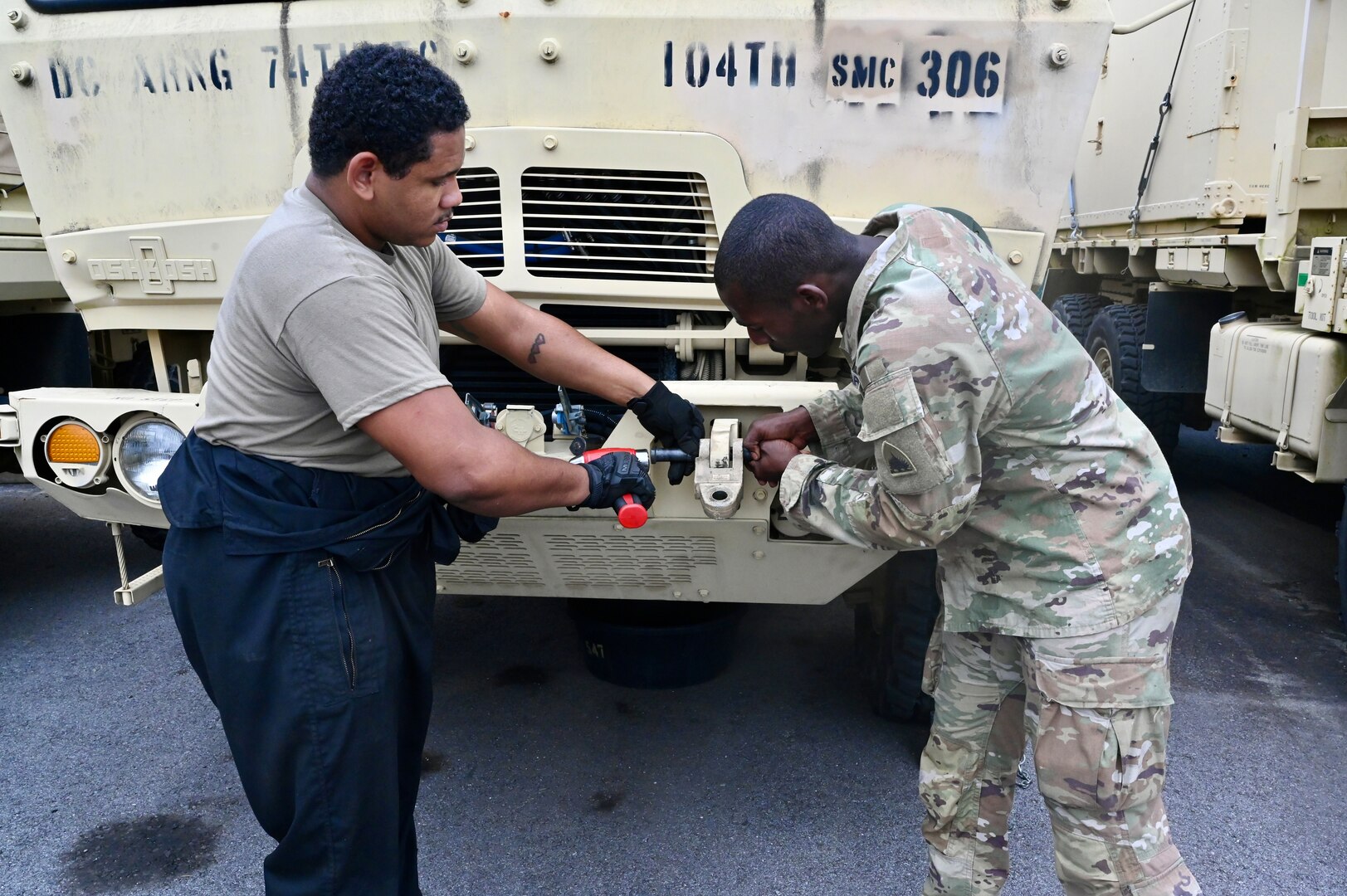 U.S. Army Pfc. James Ray, generator mechanic, and Pfc. Marques Downing, wheeled vehicle mechanic, District of Columbia National Guard, install a tactical vehicle part within the Combined Support Maintenance Shop at Joint Base Anacostia-Bolling (JBAB), June 5, 2024. A native of Washington, D.C, Pfc. Ray enlisted in the Army in 2022, motivated by the travel, connections and skills serving in the National Guard provides him.