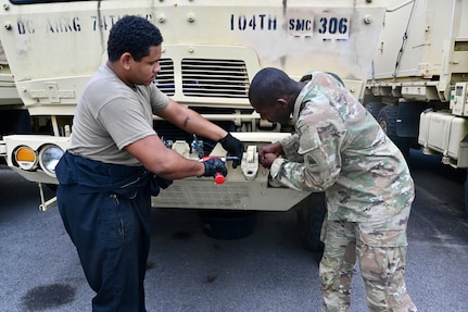 U.S. Army Pfc. James Ray, generator mechanic, and Pfc. Marques Downing, wheeled vehicle mechanic, District of Columbia National Guard, install a tactical vehicle part within the Combined Support Maintenance Shop at Joint Base Anacostia-Bolling (JBAB), June 5, 2024. A native of Washington, D.C, Pfc. Ray enlisted in the Army in 2022, motivated by the travel, connections and skills serving in the National Guard provides him.