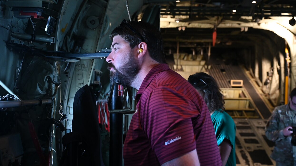 A man is looking out the window from inside an Air Force cargo plane.