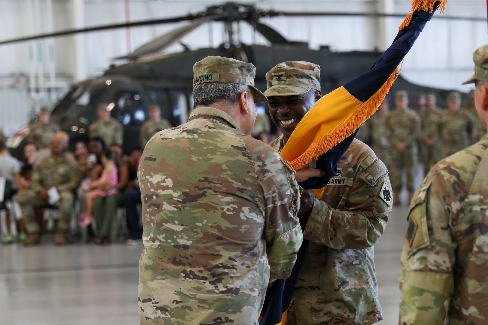 Maj. Gen. Thomas H. Mancino, adjutant general for Oklahoma, passes the brigade colors to the incoming commander of 90th Troop Command, Col. Steven D. Cheadle, at the Army Aviation Support Facility in Lexington, Oklahoma, Aug. 4, 2024. The ceremony signifies the transfer of command from outgoing commander Col. Robert W. Walker, to the incoming commander, Col. Steve D. Cheadle. (Oklahoma National Guard photo by Sgt. Connor McBride)