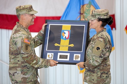 Command Sgt. Maj. Railyn Sanderson, command sergeant major for 90th Troop Command, Oklahoma Army National Guard, gifts the brigade colors to outgoing commander Col. Robert W. Walker during a change of command ceremony held at the Army Aviation Support Facility in Lexington, Oklahoma, Aug. 4, 2024. The changing of command signifies the transfer of responsibility from outgoing commander Col. Walker, to the incoming commander, Col. Steve D. Cheadle. (Oklahoma National Guard photo by Spc. Brooklyn Clark)