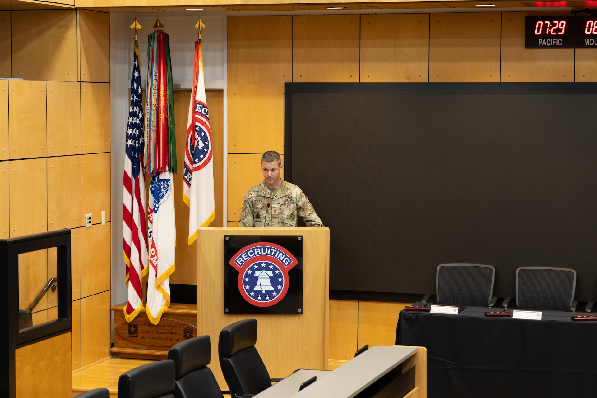 U.S. Army Soldier stands behind a USAREC podium to address the room