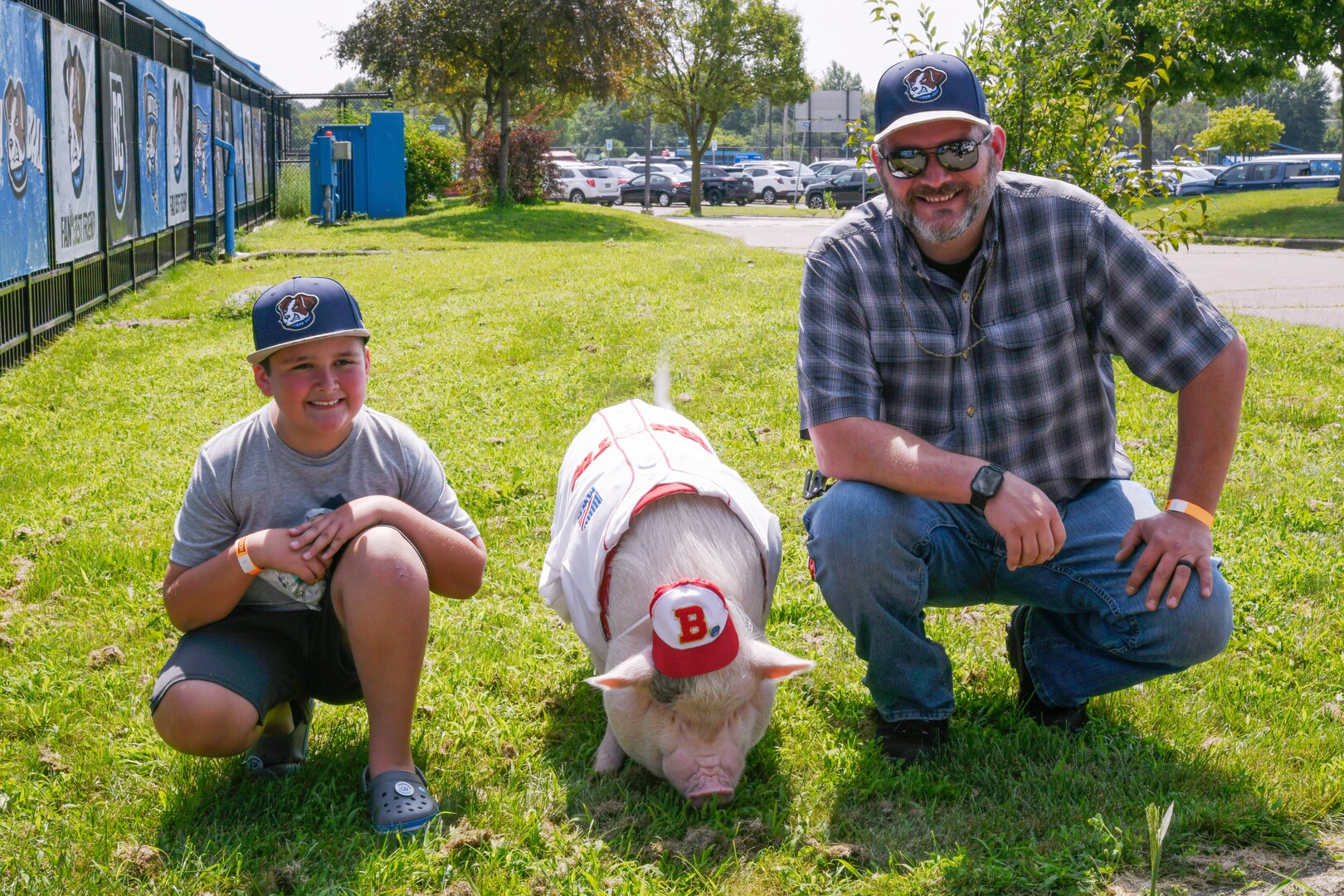 Man and child sitting kneeling by pig