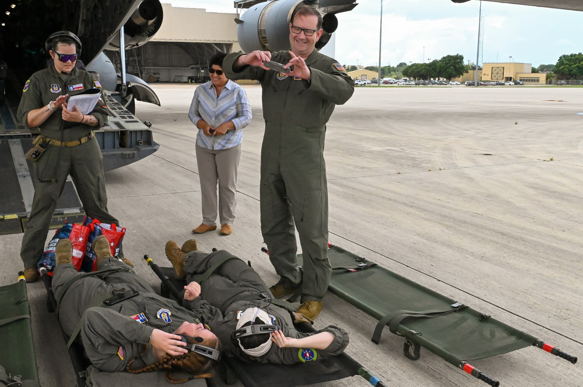 Col. Douglas Jeffrey, 433rd Airlift Wing Commander, helps two 433rd Aeromedical Evacuation Squadron Reserve Citizen Airmen take a photo during a training event at Joint Base San Antonio-Lackland, Texas July 12, 2024.