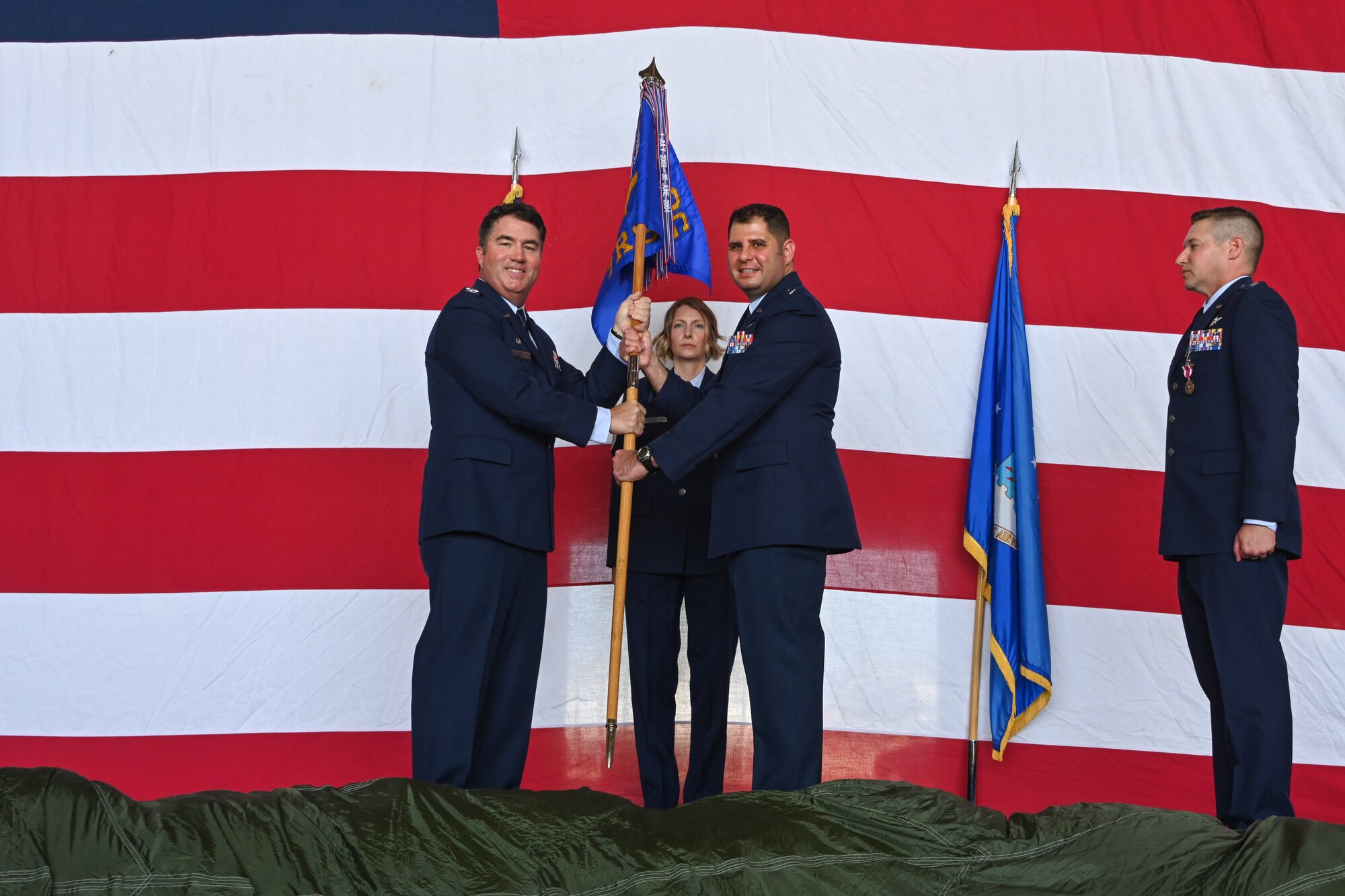 U.S. Air Force Col. John Masterson, 97th Operations Group commander, hands the 97th Training Squadron (TRS) guidon to Lt. Col. Soran Javahirzadeh during a Change of Command ceremony at Altus Air Force Base, Oklahoma, June 6, 2024. The 97th TRS oversees the training programs for C-17 Globemaster III, KC-135 Stratotaker, and KC-46 Pegasus aircraft, to ensure the production of highly qualified aircrews for the Air Force. (U.S. Air Force photo by Airman Lauren Torres)