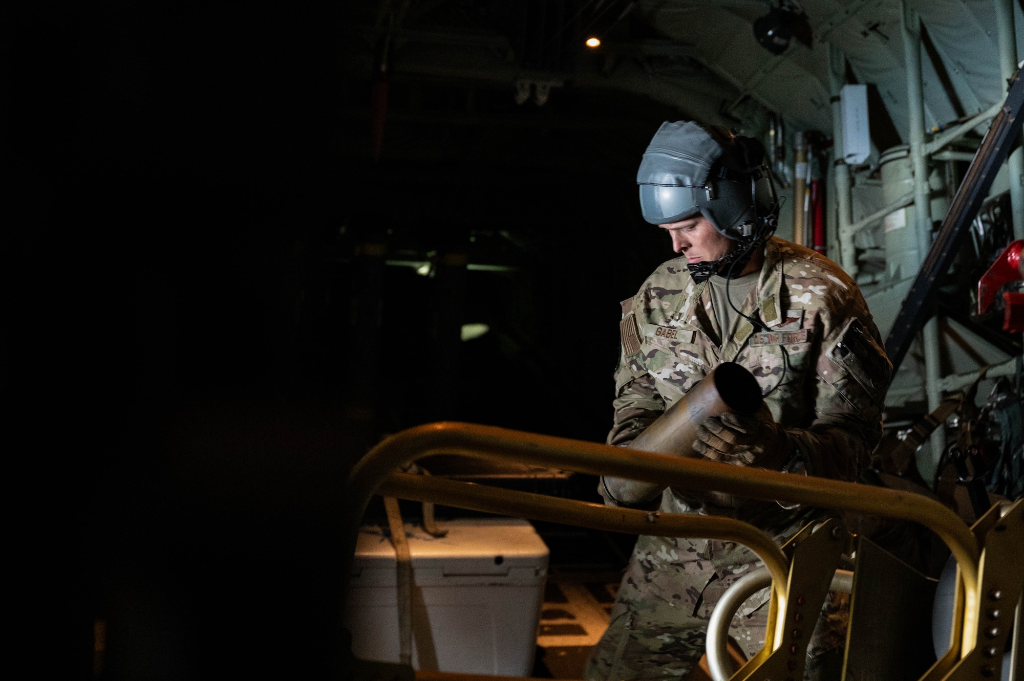 U.S. Air Force Senior Master Sgt. John Gabel, a 5th Special Operations Squadron special missions aviator, unloads a dispensed round from the 105mm cannon during AC-130J Ghostrider Gunship live fire training over Joint Base Elmendorf-Richardson, Alaska, July 19, 2024.