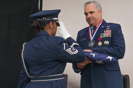 U.S. Air Force Brig. Gen. Rick L. Mutchler, Oklahoma National Guard Chief of Staff-Air, receives a U.S. flag during his retirement ceremony on August 3, 2024, at Will Rogers Air National Guard Base, Oklahoma City. Mutchler showcased his versatility and commitment to excellence throughout his career by serving in numerous roles including 137th Special Operations Wing vice commander.(U.S. Air National Guard photo by Staff Sgt. Caitlin Carnes)