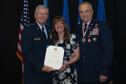 (Left to right) Retired U.S. Air Force Maj. Gen. Gregory L. Ferguson presents Andrea Mutchler, wife of Brig. Gen. Rick L. Mutchler, Oklahoma National Guard Chief of Staff-Air, with a certificate of appreciation for her unwavering support during her husband’s career in the Oklahoma Air National Guard during his retirement ceremony on August 3, 2024, at Will Rogers Air National Guard Base, Oklahoma City.  As chief of staff, Mutchler played a pivotal role in ensuring the combat readiness and operational effectiveness of the Oklahoma Air National Guard by providing invaluable guidance and support to over 2,300 Airmen across two wings, significantly enhancing the Guard’s ability to fulfill community, state and federal missions. (U.S. Air National Guard photo by Staff Sgt. Caitlin Carnes)