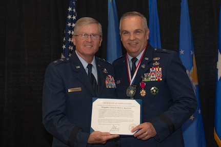 Retired U.S. Air Force Maj. Gen. Gregory L. Ferguson presents Brig. Gen. Rick L. Mutchler, Oklahoma National Guard Chief of Staff-Air, with a certificate of appreciation for his more than 40 years of service to the Oklahoma Air National Guard during his retirement ceremony on August 3, 2024, at Will Rogers Air National Guard Base, Oklahoma City. Mutchler’s exemplary service earned him numerous awards and decorations including the Legion of Merit, Meritorious Service Medal with three oak leaf clusters, and the Air Force Commendation Medal with one oak leaf cluster. (U.S. Air National Guard photo by Staff Sgt. Caitlin Carnes)