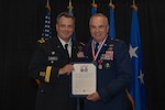 U.S. Army  Maj. Gen. Thomas H. Mancino, adjutant general for Oklahoma, presents U.S. Air Force Brig. Gen. Rick L. Mutchler, Oklahoma National Guard Chief of Staff-Air, with the Stanley F.H. Newman Award for his exemplary service to the Oklahoma Air National Guard during his retirement ceremony on Aug. 3, 2024, at Will Rogers Air National Guard Base, Oklahoma City. During the ceremony, Mancino praised Mutchler for his exemplary career and the profound impact he has had on the Airmen of the Oklahoma Air National Guard. (U.S. Air National Guard photo by Staff Sgt. Caitlin Carnes)