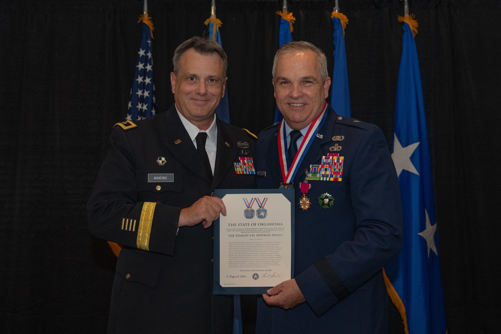 U.S. Army  Maj. Gen. Thomas H. Mancino, adjutant general for Oklahoma, presents U.S. Air Force Brig. Gen. Rick L. Mutchler, Oklahoma National Guard Chief of Staff-Air, with the Stanley F.H. Newman Award for his exemplary service to the Oklahoma Air National Guard during his retirement ceremony on Aug. 3, 2024, at Will Rogers Air National Guard Base, Oklahoma City. During the ceremony, Mancino praised Mutchler for his exemplary career and the profound impact he has had on the Airmen of the Oklahoma Air National Guard. (U.S. Air National Guard photo by Staff Sgt. Caitlin Carnes)