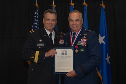 U.S. Army  Maj. Gen. Thomas H. Mancino, adjutant general for Oklahoma, presents U.S. Air Force Brig. Gen. Rick L. Mutchler, Oklahoma National Guard Chief of Staff-Air, with the Stanley F.H. Newman Award for his exemplary service to the Oklahoma Air National Guard during his retirement ceremony on Aug. 3, 2024, at Will Rogers Air National Guard Base, Oklahoma City. During the ceremony, Mancino praised Mutchler for his exemplary career and the profound impact he has had on the Airmen of the Oklahoma Air National Guard. (U.S. Air National Guard photo by Staff Sgt. Caitlin Carnes)