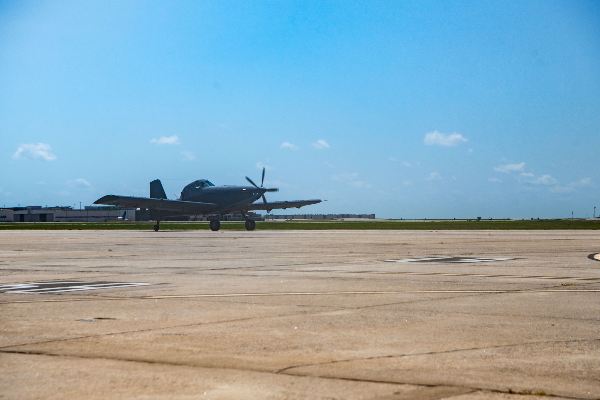 An AT-802U trainer aircraft lands on the flightline