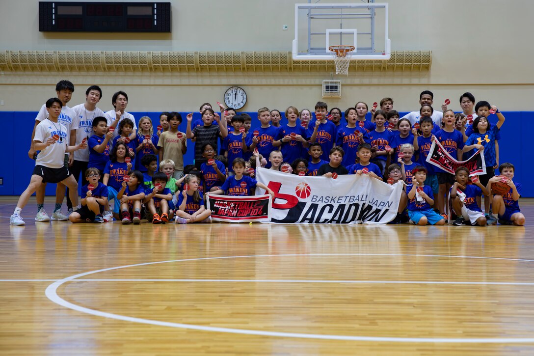 Coaches from Basketball Japan Academy and children from MCAS Iwakuni and Iwakuni City pose for a group photo after participating in the Youth Sports Summer Basketball Camp at Atago Hills Sports Complex, Iwakuni, Japan, July 26, 2024. The Youth Sports Summer Basketball Camp coached by Basketball Japan Academy builds technical skills, aids in social development, and promotes an active lifestyle for kids ages six through eighteen. (U.S. Marine Corps photo by Lance Cpl. Dahkareo Pritchett)