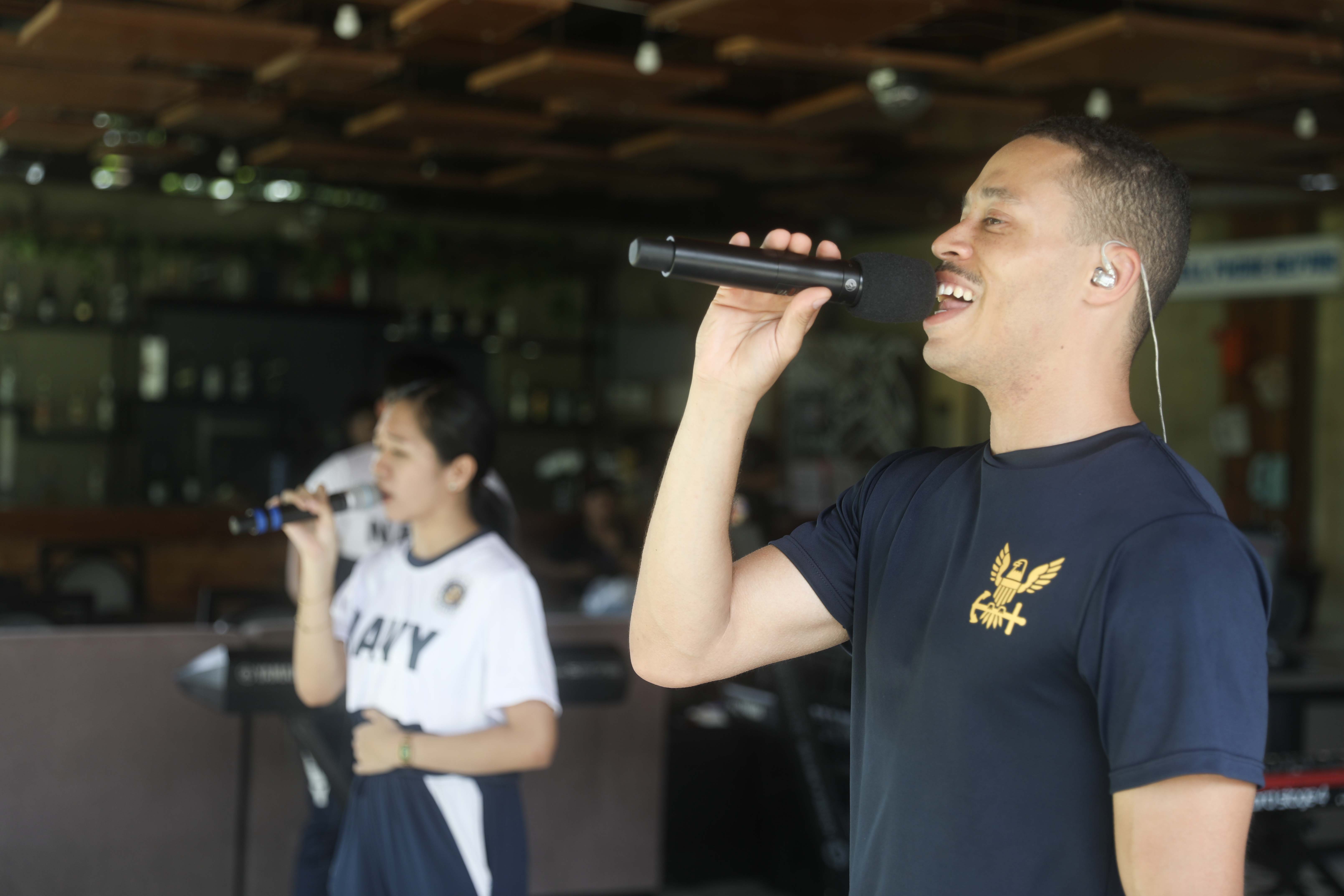 LEGAZPI, Philippines (Aug. 3, 2024) – U.S. Navy Musician 3rd Class Damian Chambers, right, of Marietta, Ga., and Philippine Navy applicant Darlene Brioso, with the Philippine Navy Seabees Band, sing together during a subject matter expert exchange in Legazpi, Philippines, Aug. 3, 2024. The subject matter expert exchange was used to integrate the Seabees band with the Pacific Partnership 24-2 band in order to play several shows together throughout Legazpi. Now in its 20th iteration, the Pacific Partnership series is the largest annual multinational humanitarian assistance and disaster relief preparedness mission conducted in the Indo-Pacific. Pacific Partnership works collaboratively with host and partner nations to enhance regional interoperability and disaster response capabilities, increase security and stability in the region, and foster new and enduring friendships in the Indo-Pacific. (U.S. Navy photo by Mass Communication Specialist 1st Class Ryan D. McLearnon/Released)
