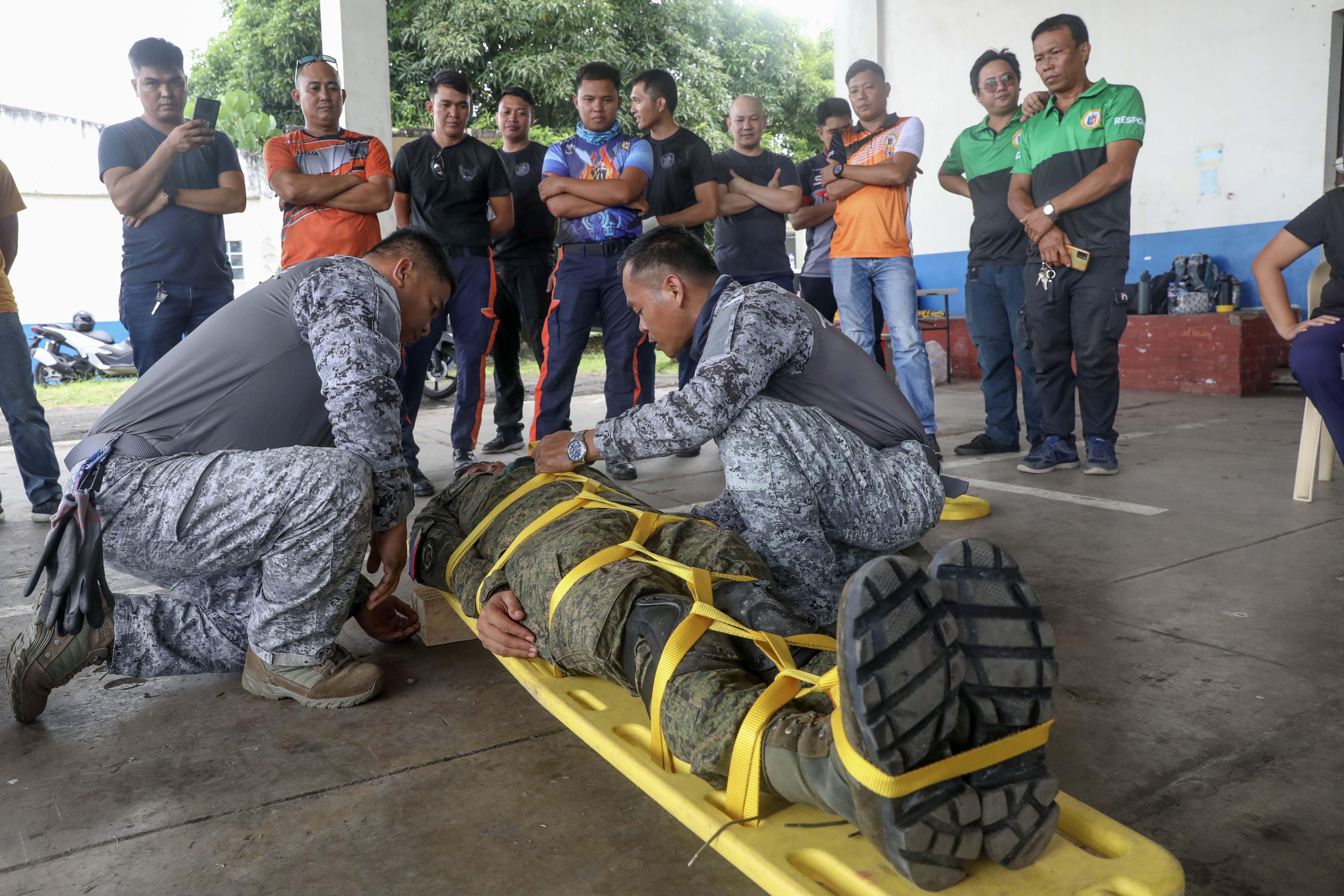 LEGAZPI, Philippines (Aug. 1, 2024) – Philippine Air Force Tech. Sgt. Peter John Patal, left, and MSG Luther P. Melo, both of the 505th Search and Rescue Group demonstrate patient packaging on Philippine Army Cpl. Jerald N. Calvadores of the 525th Combat Engineer Battalion on a stretcher during an urban rescue training in support of the humanitarian aid and disaster response line of effort of Pacific Partnership 24-2 at the Legazpi airport in Legazpi, Philippines, Aug. 1, 2024. The training brought U.S. service members together with members of the 505th Search and Rescue Group, Philippine Air Force, the 525th Combat Engineer Battalion of Combat Engineer Regiment of the Philippine Army, Legazpi City officials, the Disaster Risk Reduction and Management Office and members of the Bureau of Fire Protection, to share ideas and experiences allowing them to teach and learn from one another. Now in its 20th iteration, the Pacific Partnership series is the largest annual multinational humanitarian assistance and disaster relief preparedness mission conducted in the Indo-Pacific. Pacific Partnership works collaboratively with host and partner nations to enhance regional interoperability and disaster response capabilities, increase security and stability in the region, and foster new and enduring friendships in the Indo-Pacific. (U.S. Navy photo by Mass Communication Specialist 1st Class Ryan D. McLearnon/Released)