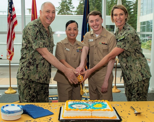 Navy Medicine Leadership and MSC Legacy… Navy Medicine Readiness Training Command Bremerton’s Medical Service Corps most senior officer, Capt. Maria Edusada, director of administration and junior member, Lt. j.g. David Tegtmeyer, deputy chief information officer and operations management department head, engage in the traditional cake-cutting portion of the birthday celebration for their MSC 77th birthday (official date, August 4, 1947), assisted by Capt. Patrick Fitzpatrick, Naval Hospital Bremerton director and NMRTC Bremerton commanding officer and Capt. Karla Lepore, incoming NHB director, NMRTC Bremerton commanding officer and MSC officer (Official Navy photo by Mass Communication Specialist 2nd Class Jennifer Benedict, NHB/NMRTC Bremerton public affairs).