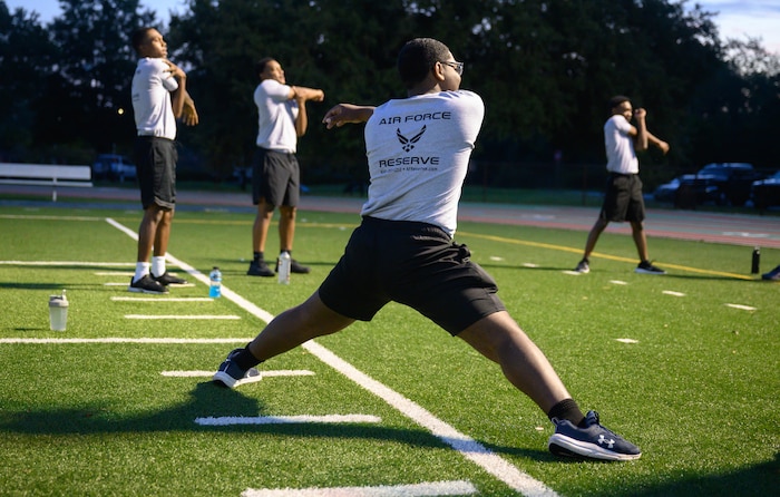 Development and Training Flight trainees assigned to the 315th Airlift Wing, Joint Base Charleston, S.C. and 908th Flying Training Wing, Maxwell Air Force Base, Ala., perform warm-up stretches prior to a morning run on the physical training track during their unit training assembly immersion tour of Air Force Reserve Command, Robins Air Force Base, Ga. Sunday, Aug. 4, 2024.
