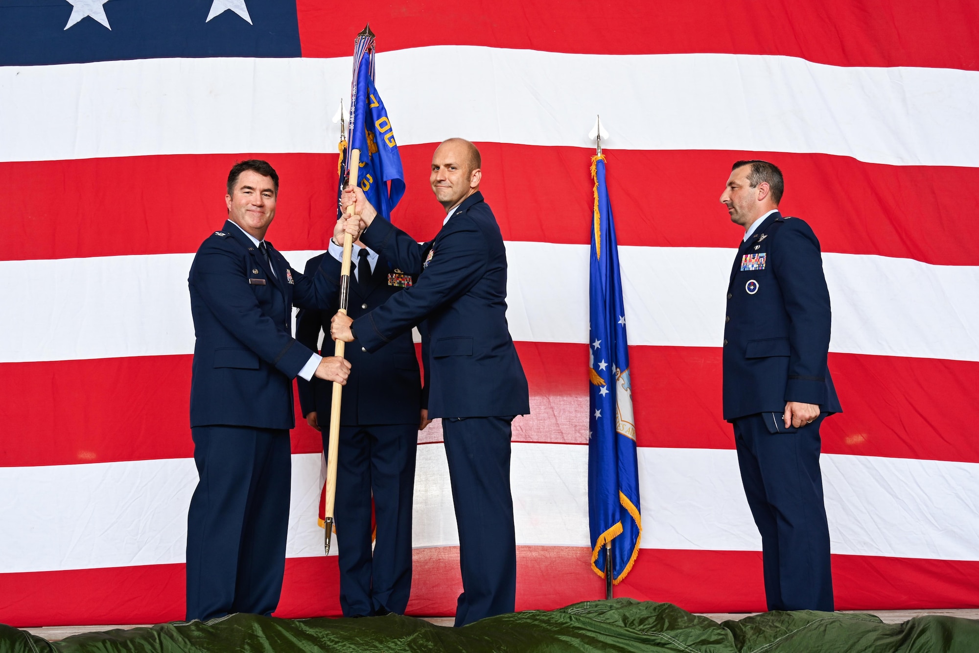 U.S. Air Force Col. John Masterson, 97th Operations Group commander, passes the 97th Operations Support Squadron (OSS) guidon to Lt. Col. Christopher Schlener, 97th OSS commander, during a change of command ceremony at Altus Air Force Base (AFB), Oklahoma, May 7, 2024. The 97th OSS is composed of 180 members across six flights, responsible for Altus AFB’s 23,970 flying hour program worth $271M for over 277 instructors and 2,114 C-17, KC-135, and KC-46 students annually. (U.S. Air Force photo by Airman 1st Class Jonah Bliss)