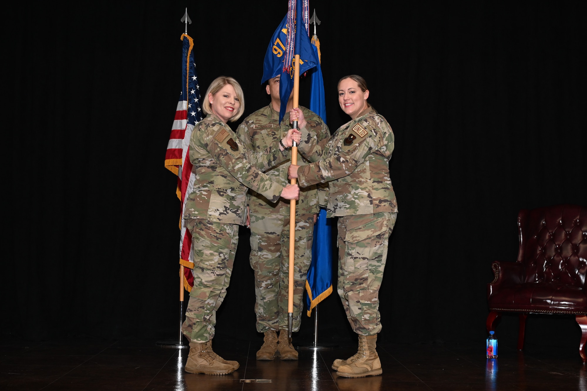 U.S. Air Force Col. Tammy Hollister, 97th Mission Support Group commander, hands the 97th Contracting Flight (CONF) guidon to Maj. Chelsea Brincka, 97th CONF commander, during an assumption of command ceremony at Altus Air Force Base, Oklahoma, July 2, 2024. The 97th CONF is responsible for acquiring goods and services necessary to support the mission of the Mighty 97th. (U.S. Air Force photo by Airman Lauren Torres)