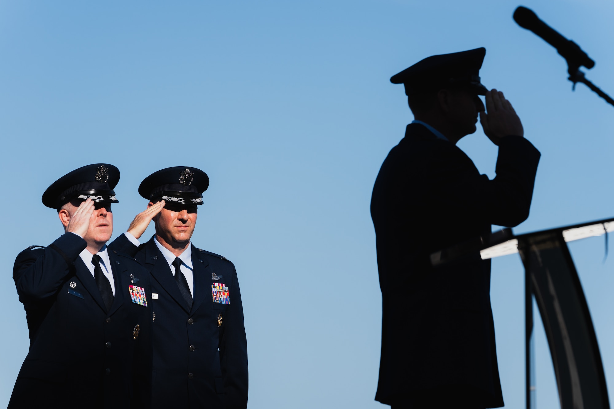U.S. Air Force Col. Adam Bingham, left, Col. Edward Szczepanik, middle, and Maj. Gen. Corey Martin, 18th Air Force commander, render salutes during the national anthem at MacDill Air Force Base, Florida, Aug. 2, 2024.