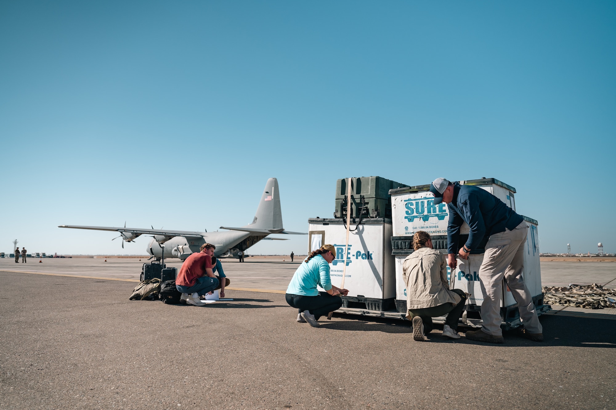 Aerial porters from the 387th Air Expeditionary Squadron’s Quick Reaction Team strap down crates onto a pallet.