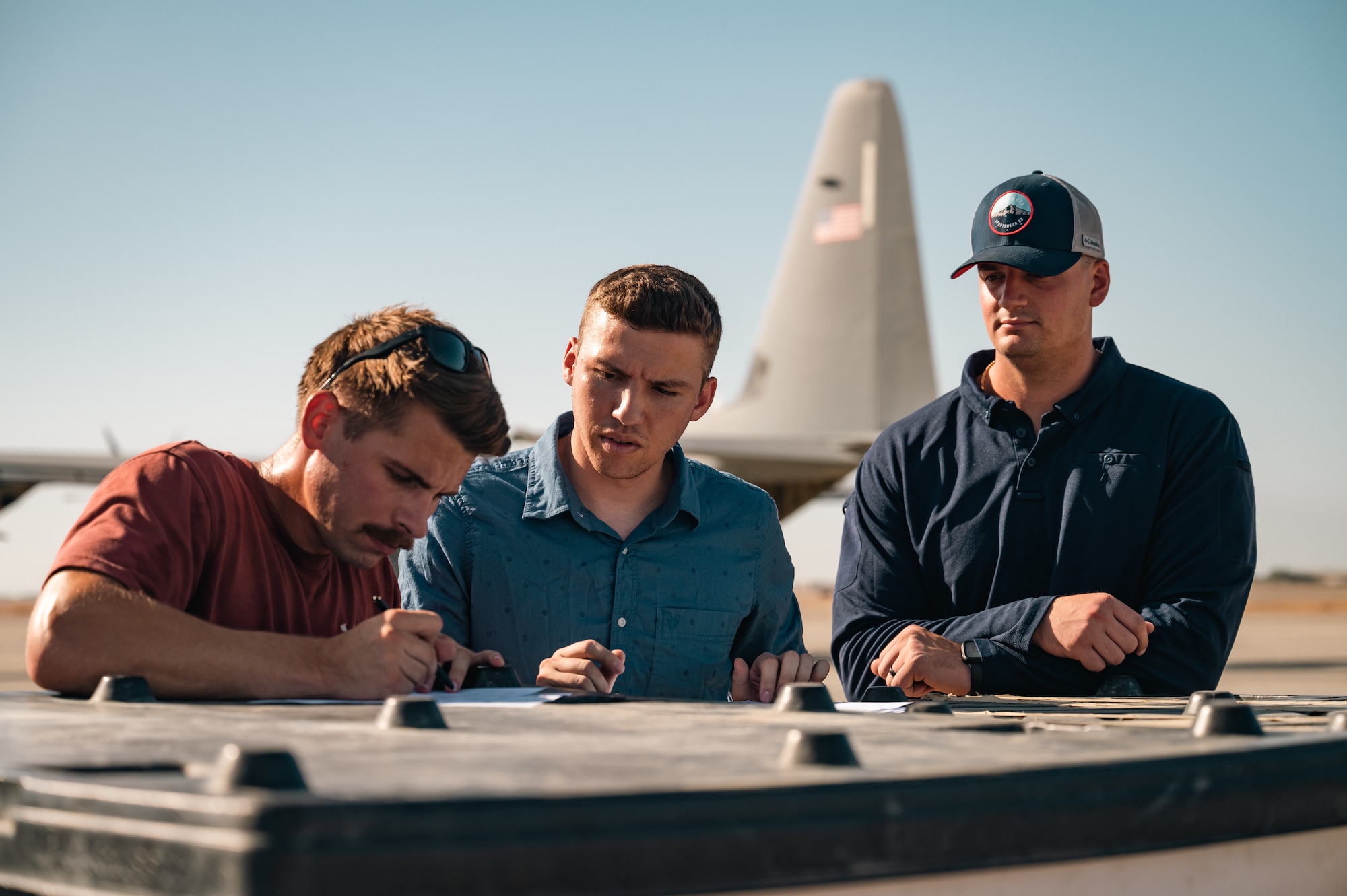 Aerial porters from the 387th Air Expeditionary Squadron’s Quick Reaction Team sign papers.