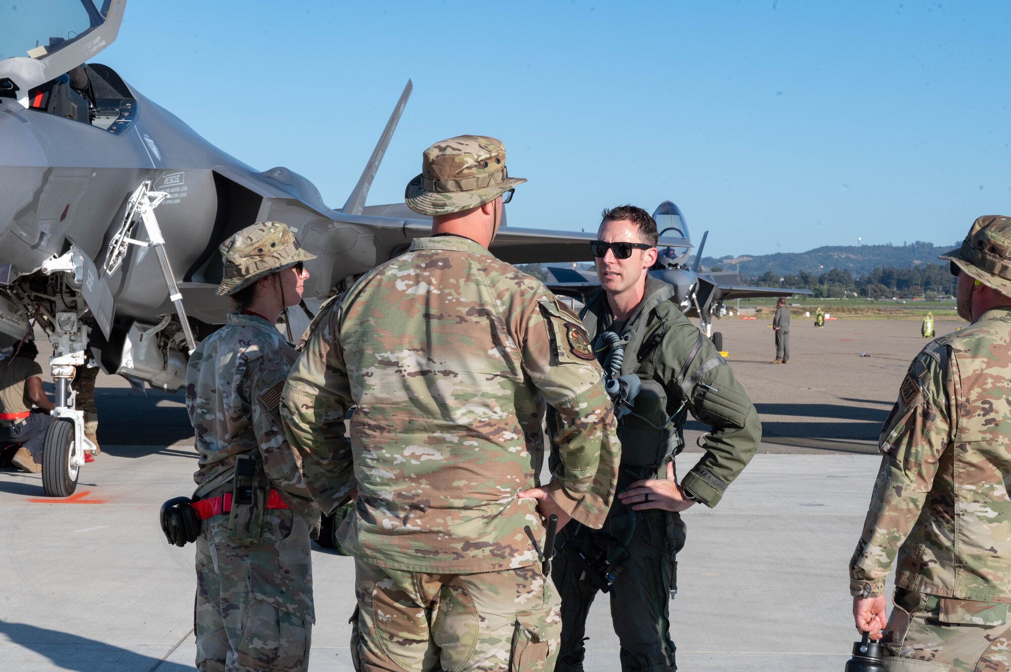 A photo of Airmen talking near a jet