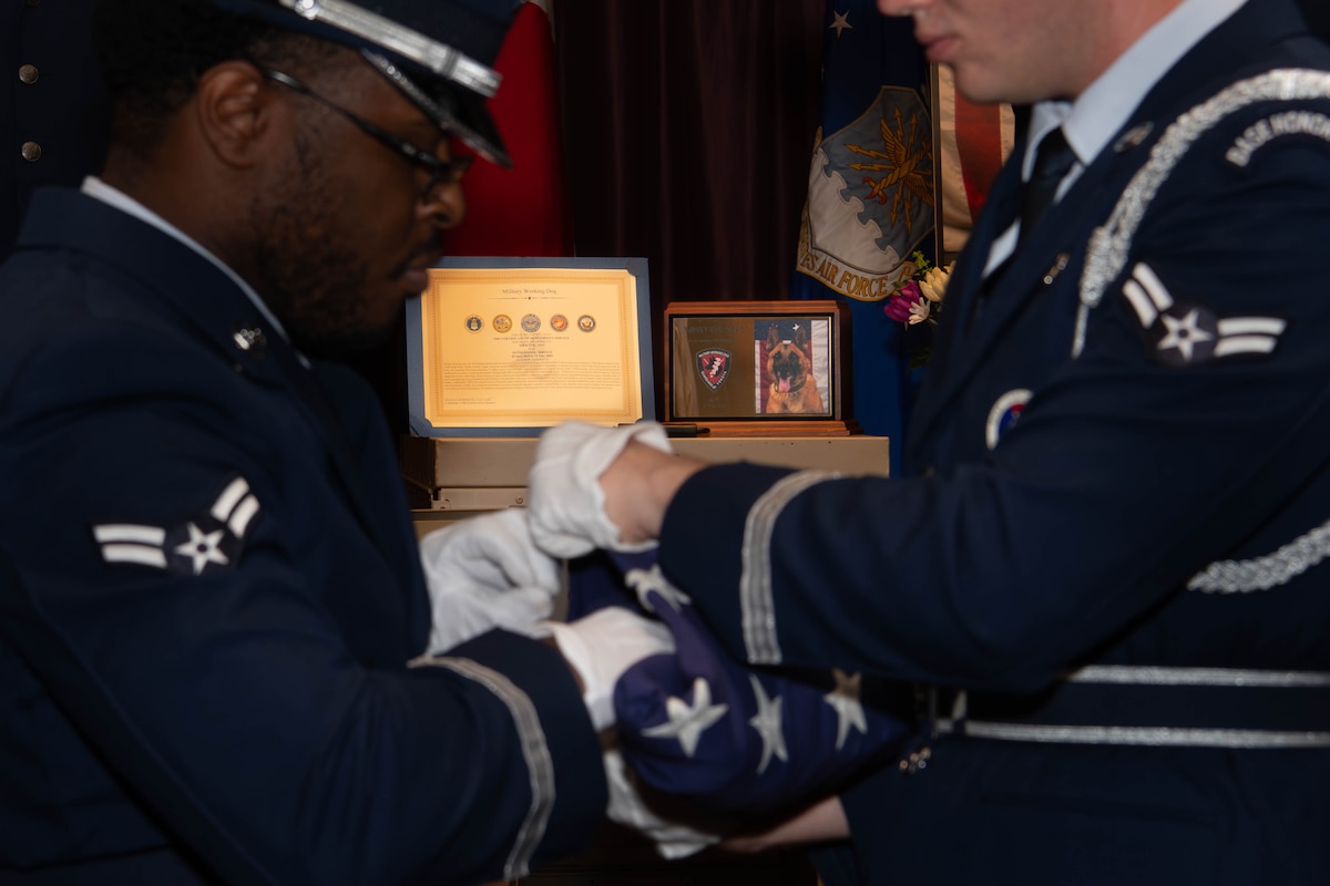 Yokota Air Base honor guardsmen fold a flag to honor Tek.
