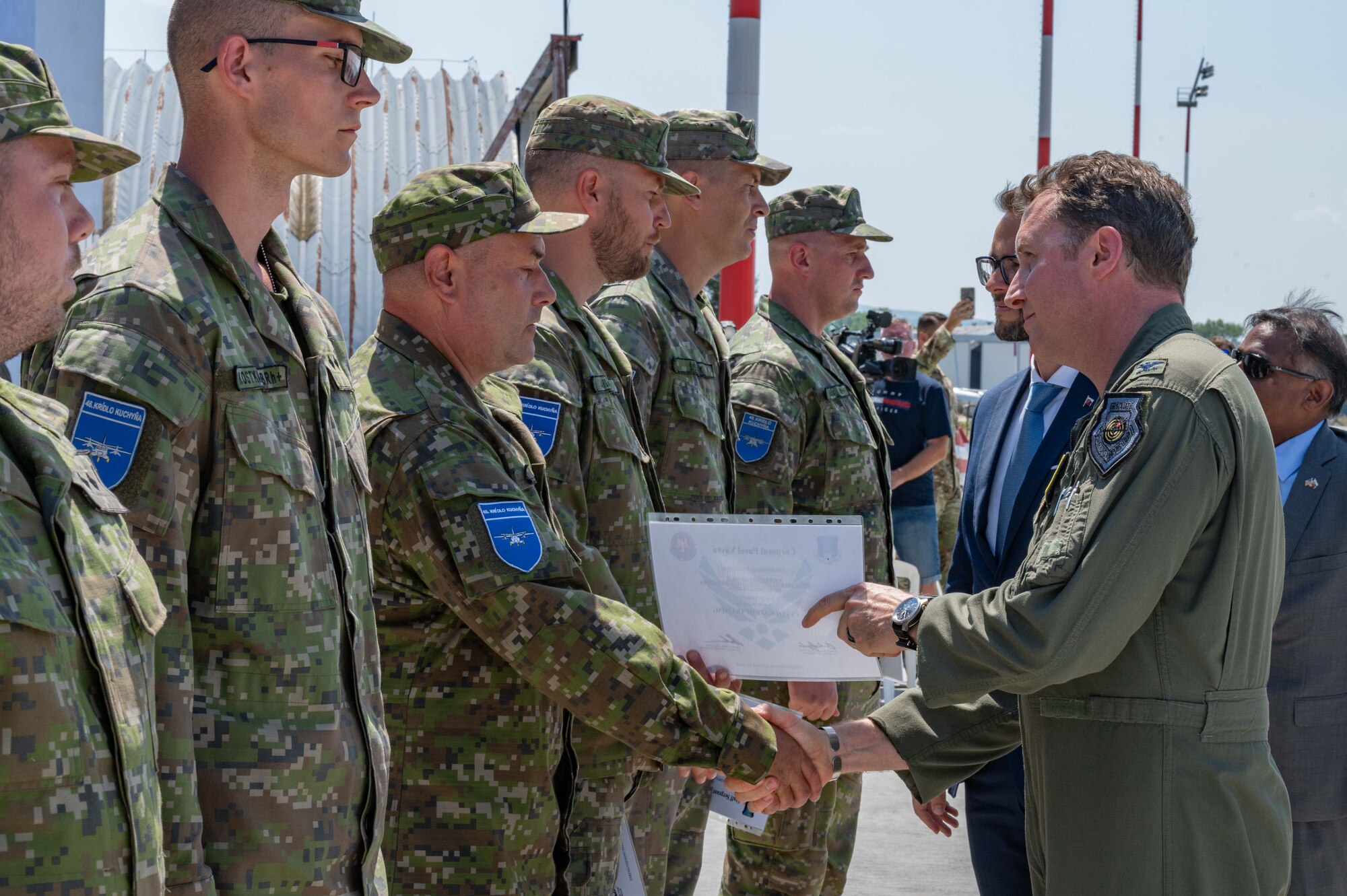 U.S. Air Force Col. Matthew Bartlett, 435th Air Ground Operation Wing commander, presents a certificate of training to Slovak Air Force members at Malacky Air Base, Slovakia, July 10, 2024. Six Slovak AF members were awarded the certificates for completing the USAF BAK-12 Aircraft Arresting System Operations and Maintenance training. (U.S. Air Force photo by Airman 1st Class Eve Daugherty)