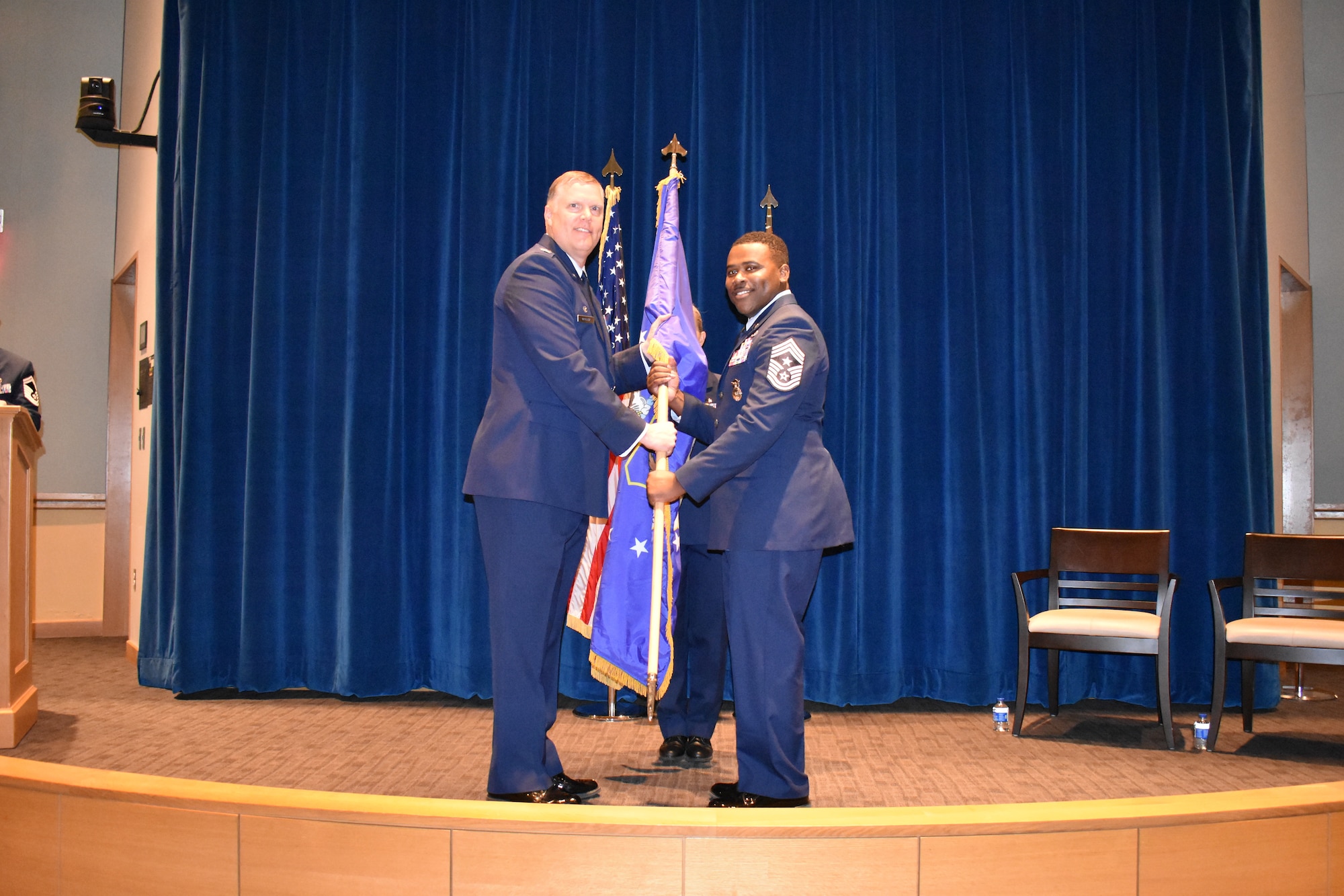 Chief Master Sgt. Aaron Doss (right) accepts the unit flag from Col. Philip Warlick, 655th Intelligence, Surveillance and Reconnaissance (ISR) Wing commander, during an assumption of command ceremony Aug. 3, 2024.