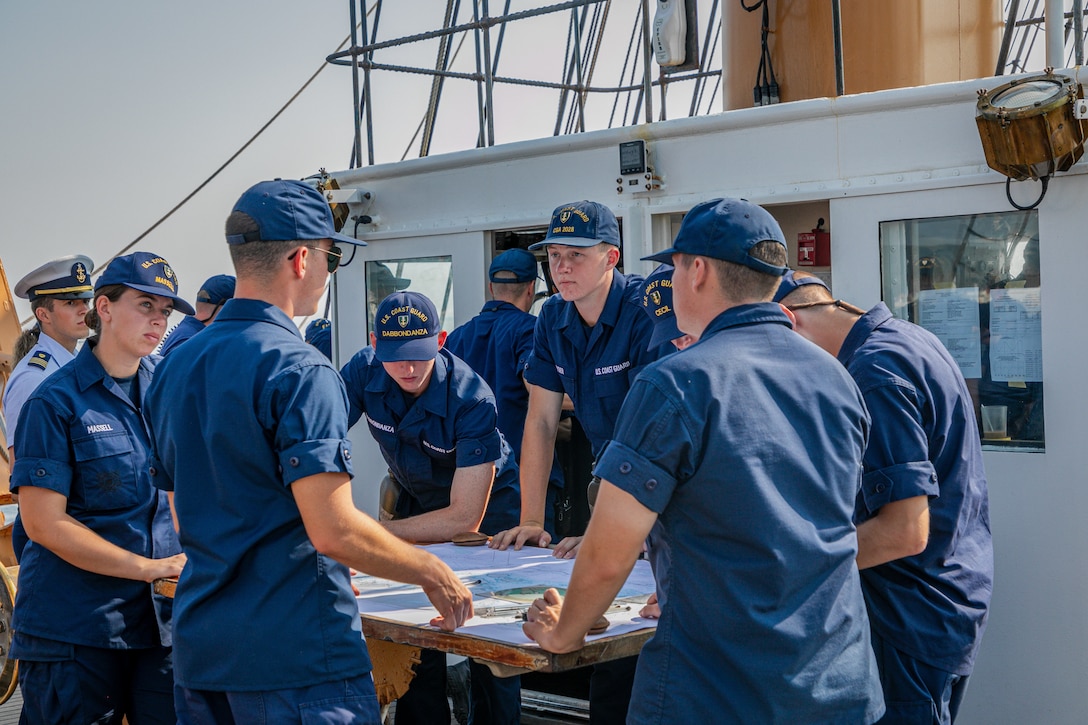 U.S. Coast Guard Academy cadets listen to Coast Guard Cutter Eagle crewmembers during Eagle's transit into Rockland Harbor, Aug. 2, 2024. Eagle, the Coast Guard's First District, and Coast Guard Station Rockland celebrated Rockland recertifying as a Coast Guard City.