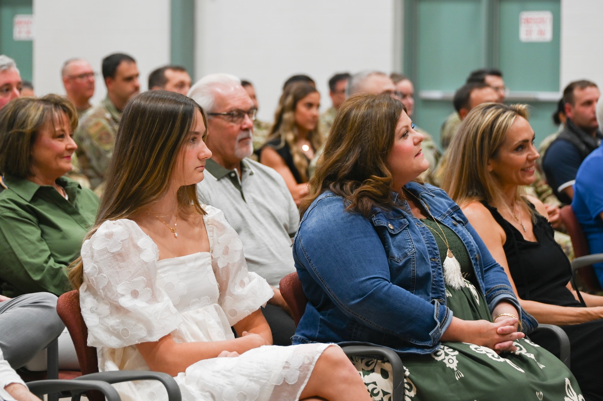 Abby and Ashley Snodgrass, daughter and wife of Lt. Col. David Snodgrass, 301st Operations Group commander, watch as he assumes command of the 301st OG Aug. 3, 2024 at Naval Air Station Joint Reserve Base Fort Worth, Texas. During the ceremony, Snodgrass thanked his family for their resilience throughout his service and for always supporting him.