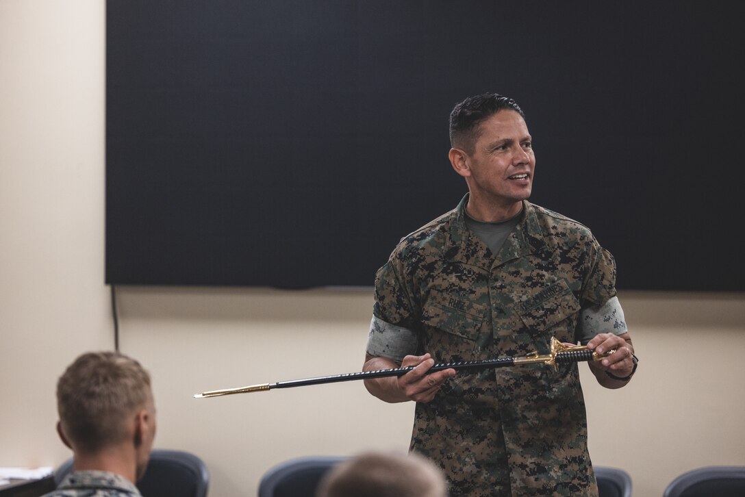 U.S. Marine Corps Sgt. Maj. Carlos Ruiz, 20th Sergeant Major of the Marine Corps, speaks to Marines about sword manual during Corporals Course 11-24 on Camp Lejeune, North Carolina, Aug. 2, 2024. 2nd Marine Logistics Group Corporals Course is a professional military education program designed to provide Marines with the basic knowledge and skills necessary to assume greater responsibility as a non-commissioned officer, that places emphasis on basic leadership skills, 2nd MLG's unit structure and their role in warfighting. (U.S. Marine Corps photo by Cpl. Meshaq Hylton)