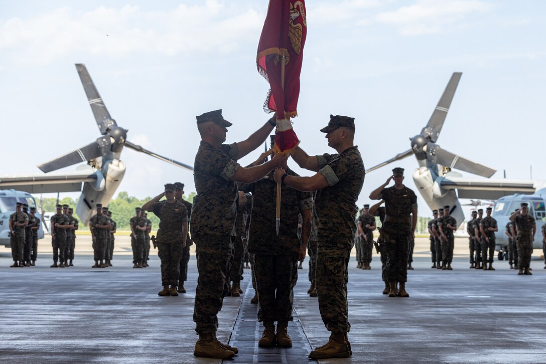 U.S. Marine Corps Lt. Col. Sean Rafferty, right, a native of New Jersey, and the outgoing commanding officer of Marine Medium Tiltrotor Squadron (VMM) 263, passes the unit colors to Lt. Col. Terry Carter, left, oncoming commanding officer of VMM-263, during a change of command ceremony at Marine Corps Air Station New River, North Carolina, Aug. 1, 2023. The ceremony represented a transfer of responsibility, authority, and accountability from Rafferty to Carter. (U.S. Marine Corps photo by Lance Cpl. Orlanys Diaz Figueroa)