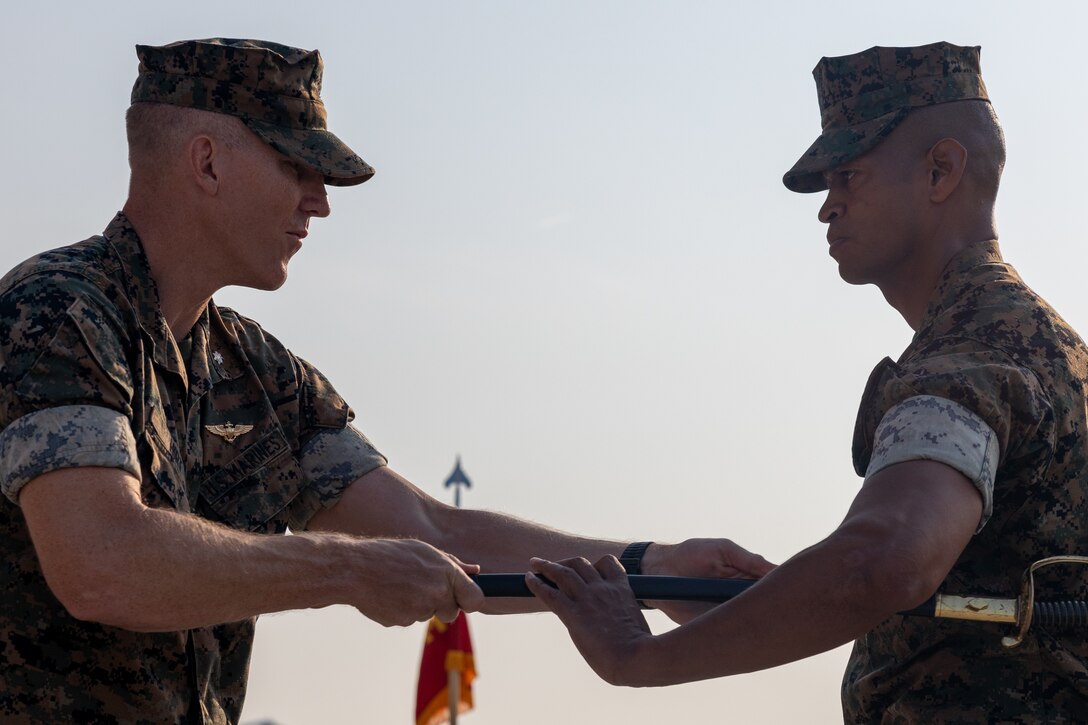 U.S. Marine Corps Sgt. Maj. Jose M. Ramirez, right, from Texas and command senior enlisted leader, receives the sword of office from Lt. Col. David A. Hirt from Illinois, both with Marine Light Attack Helicopter Squadron (HMLA) 167, during a relief and appointment ceremony at Marine Corps Air Station New River, North Carolina, Aug. 1, 2024. The ceremony represented a transfer of responsibility, authority, and accountability from Sgt. Maj. Alexander Bruffy to Sgt. Maj. Jose M. Ramirez. (U.S. Marine Corps photo by Lance Cpl. Madison Blackstock)