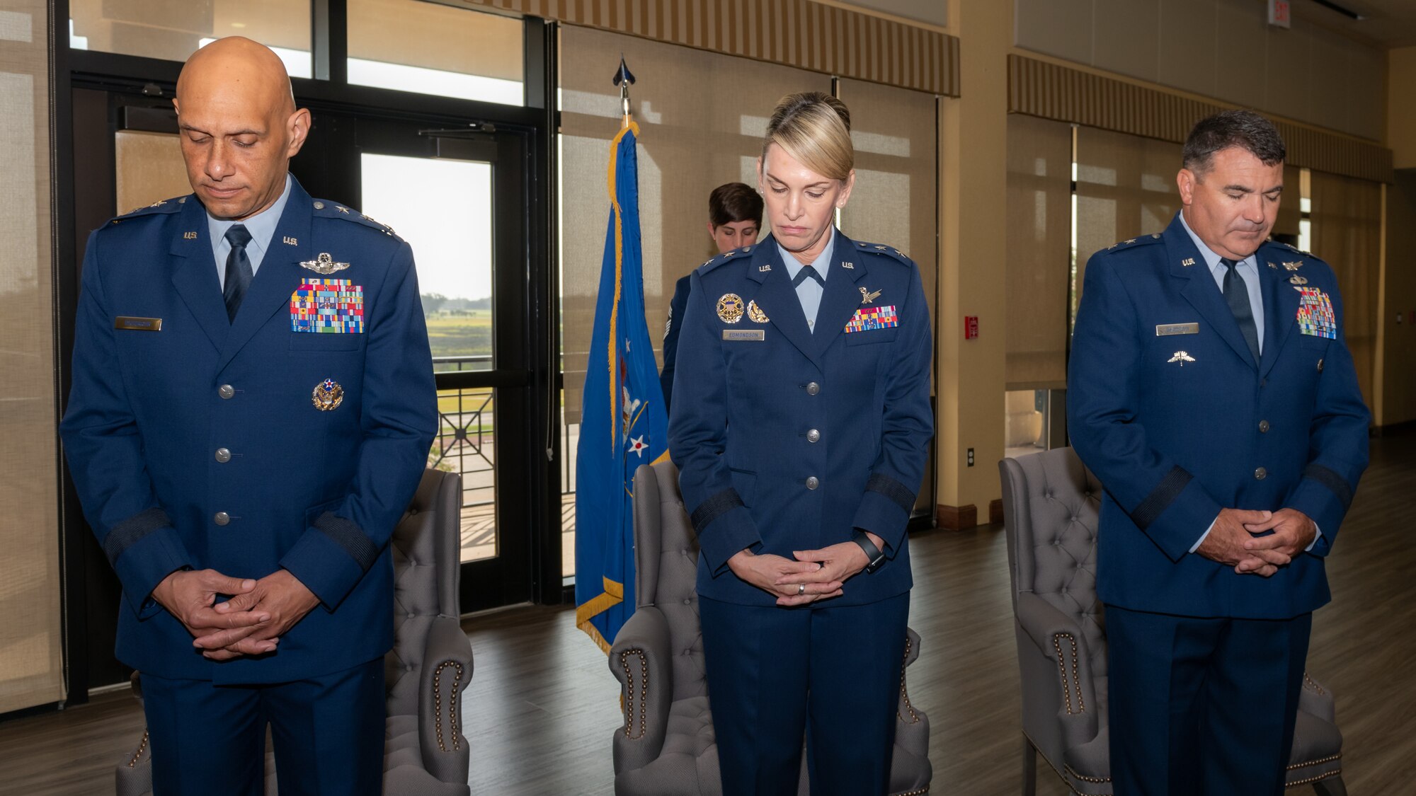 U.S. Air Force Lt. Gen. Brian Robinson, Air Education and Training Command commander, Maj. Gen. Michele Edmondson, Second Air Force outgoing commander and Maj. Gen. Matthew Wolfe Davidson, Second Air Force incoming commander, bow their heads during the invocation at the Second Air Force change of command ceremony inside the Bay Breeze Event Center at Keesler Air Force Base, Mississippi, Aug 2, 2024.