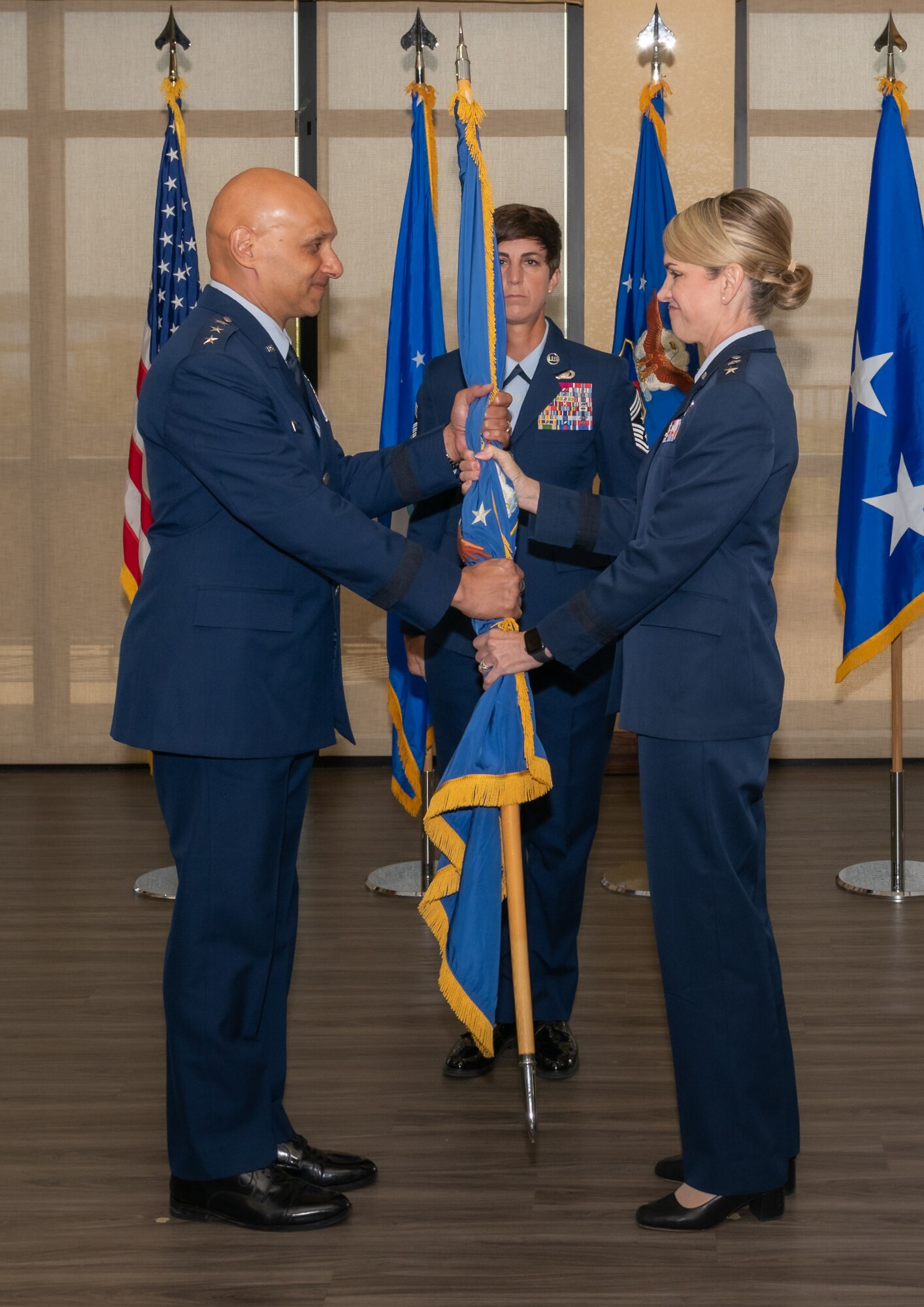 U.S. Air Force Lt. Gen. Brian Robinson, Air Education and Training Command commander, retrieves the guidon from Maj. Gen. Michele Edmondson, Second Air Force outgoing commander, as she relinquishes command during the Second Air Force change of command ceremony inside the Bay Breeze Event Center at Keesler Air Force Base, Mississippi, Aug 2, 2024.