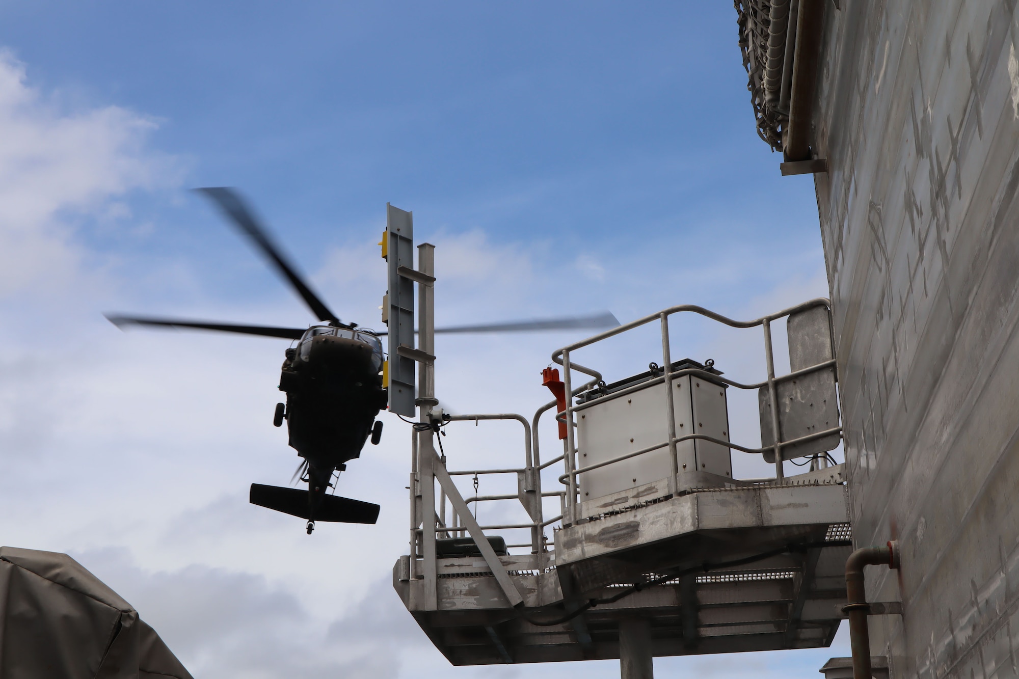 A photo of a helicopter over a ship.
