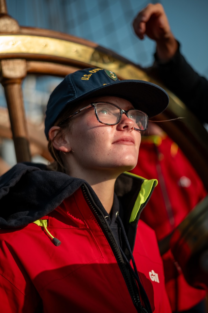 A Coast Guard Academy Cadet stands watch at the helm of Coast Guard Cutter Eagle (WIX 327) while sailing off the coast of Maine, July 30, 2024. The Eagle serves as a classroom at sea, giving all officers a foundation in seamanship and life underway.