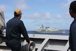 SOUTH CHINA SEA (Aug. 7, 2024) A U.S. Navy Sailor assigned to the Ticonderoga-class guided-missile cruiser USS Lake Erie (CG 70), observes the Royal Canadian Navy Halifax-class frigate HMCS Montreal (FFH 336), while in formation a quadrilateral Maritime Cooperation Activity exercise with the Australia, Canada, the Philippines and the U.S., Aug. 7, 2024. Lake Erie is assigned to Destroyer Squadron (DESRON) 15, the Navy’s largest DESRON and the U.S. 7th Fleet’s principal surface force. 7th Fleet is the U.S. Navy’s largest forward-deployed numbered fleet, and routinely interacts and operates with allies and partners in preserving a free and open Indo-Pacific region. (U.S. Navy photo by Lt. j.g. Selena Esteban)