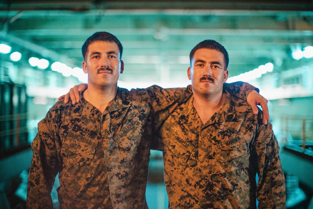 U.S. Marine Corps Gunnery Sgt. Joseph Morelli, left, the communications maintenance chief assigned to the 15th Marine Expeditionary Unit, and Sgt. Albert Morelli, an assistant patrol leader assigned to Bravo Company, Battalion Landing Team 1/5, 15th MEU, pose for a photo in the well deck of the amphibious assault ship USS Boxer (LHD 4) in the Pacific Ocean Aug. 4, 2024. Gunnery Sgt. Morelli and Sgt. Morelli, identical twins from Cheyenne, Wyoming, enlisted together in the Marine Corps in 2009 and are both underway aboard Boxer supporting the 15th MEU’s routine operations in the U.S. 7th Fleet area of operations. 7th Fleet is the U.S. Navy’s largest forward-deployed numbered fleet, and routinely interacts and operates with allies and partners in preserving a free and open Indo-Pacific region. (U.S. Marine Corps photo by Cpl. Luis Agostini)