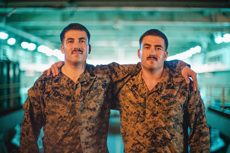 U.S. Marine Corps Gunnery Sgt. Joseph Morelli, left, the communications maintenance chief assigned to the 15th Marine Expeditionary Unit, and Sgt. Albert Morelli, an assistant patrol leader assigned to Bravo Company, Battalion Landing Team 1/5, 15th MEU, pose for a photo in the well deck of the amphibious assault ship USS Boxer (LHD 4) in the Pacific Ocean Aug. 4, 2024.