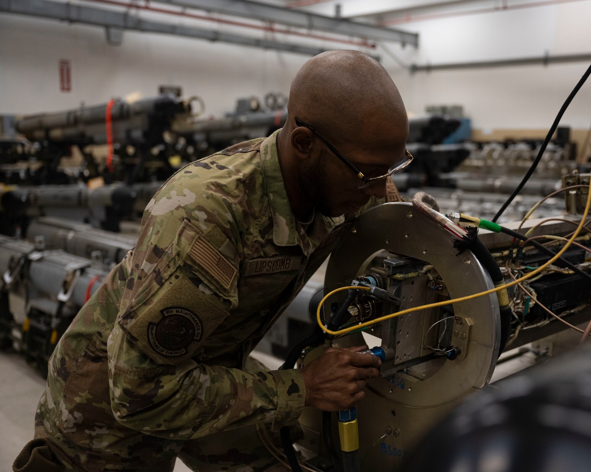 Senior Airman Myles Lipscomb, 8th Maintenance Squadron electromagnetic systems journeyman, attaches a coolanol pump hose to an ALQ-184 electronic countermeasure pod assembly at Kunsan Air Base, Republic of Korea.