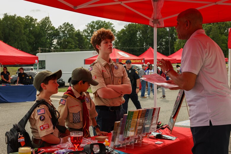 Children with Boy Scouts of America visit a drug awareness booth during the National Night Out at the Crossroads Elementary School on Marine Corps Base Quantico, Virginia, August 6, 2024. The purpose of National Night Out is to enhance the relationships between law enforcement and the people they protect. (U.S. Marine Corps photo by Lance Cpl. David Brandes)